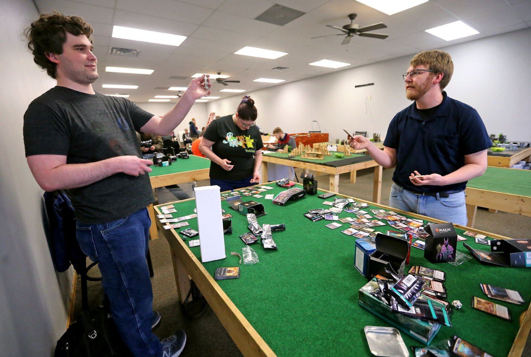 Andrew Dorn (from left), Ariana Boock and Garrett Bizzell sort cards at Comic World & Games in Dubuque on Friday, April 22, 2022. The business recently added 2,000 more square feet of space for in-person gaming.    PHOTO CREDIT: JESSICA REILLY