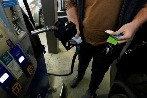 FILE - A customer prepares to pump gasoline into his car at a Sam
