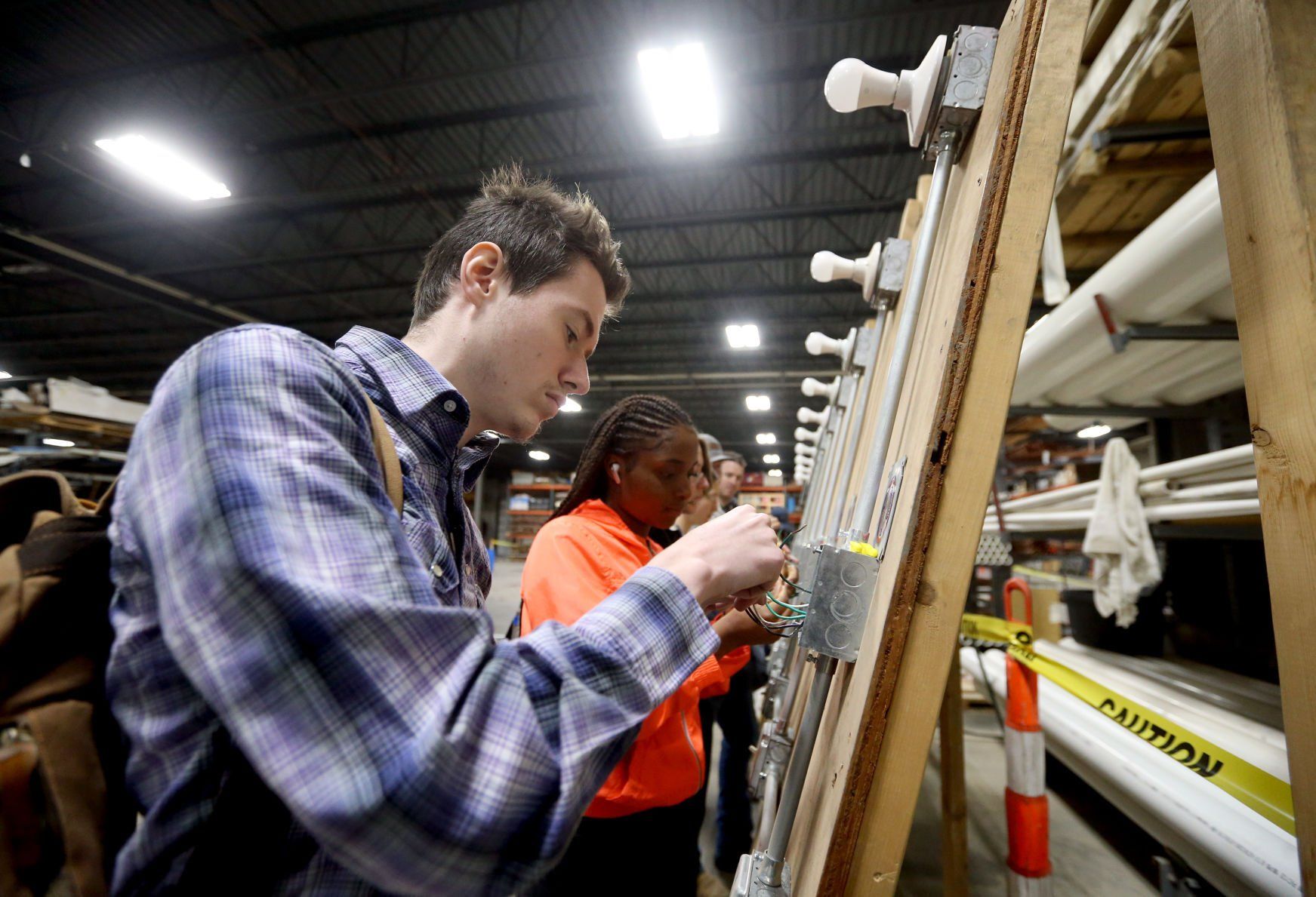 Grant Dinehart (left), a junior at Dubuque Senior High School, works to splice a junction box during the Construction Industry Career Expo at Portzen Construction in Dubuque on Thursday, April 28, 2022.    PHOTO CREDIT: JESSICA REILLY