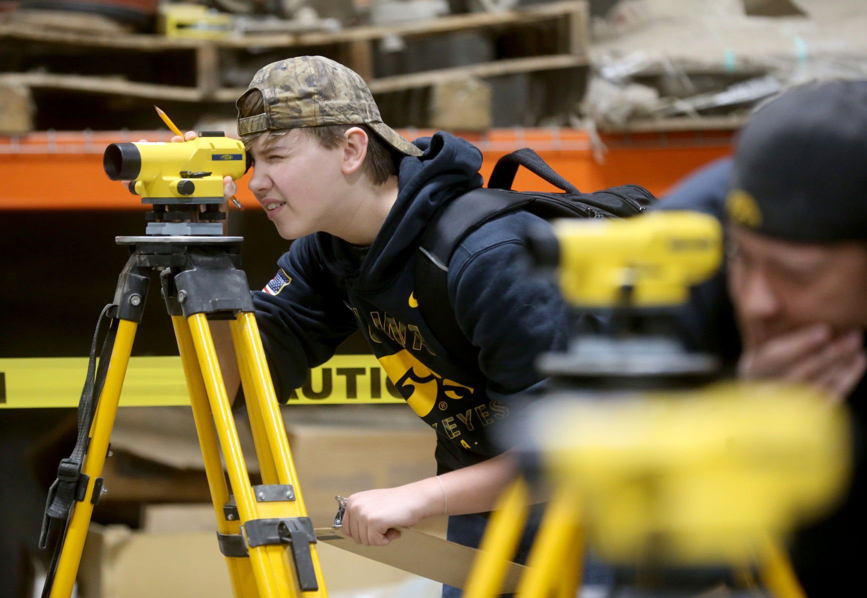 Ryan Gabel, a freshman at Dubuque Senior High School, looks through a builder’s level during the Construction Industry Career Expo at Portzen Construction in Dubuque on Thursday, April 28, 2022.    PHOTO CREDIT: JESSICA REILLY