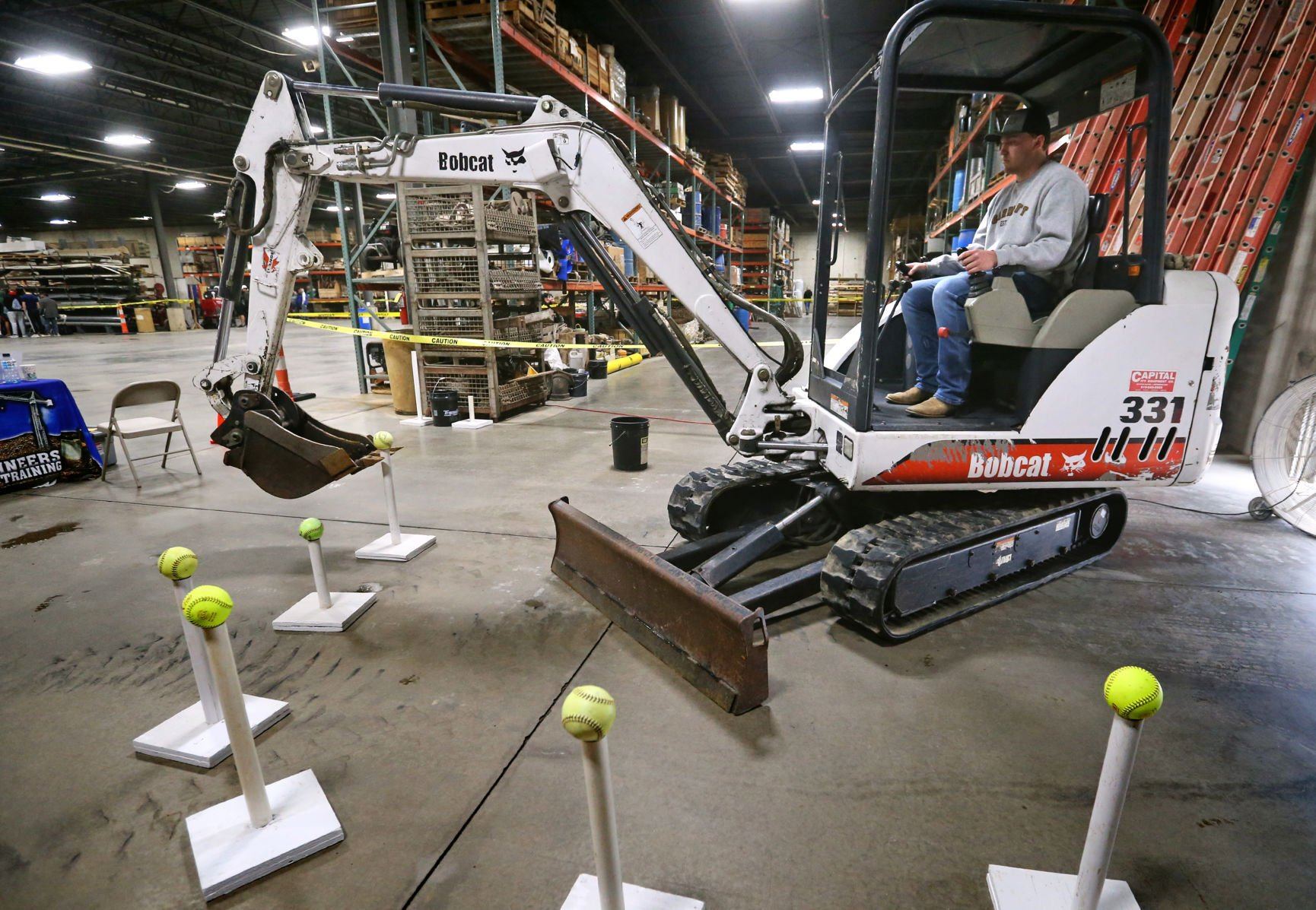 Dylan Dean, a senior at Dubuque Senior High School, uses a mini excavator during the Construction Industry Career Expo at Portzen Construction in Dubuque on Thursday, April 28, 2022.    PHOTO CREDIT: JESSICA REILLY