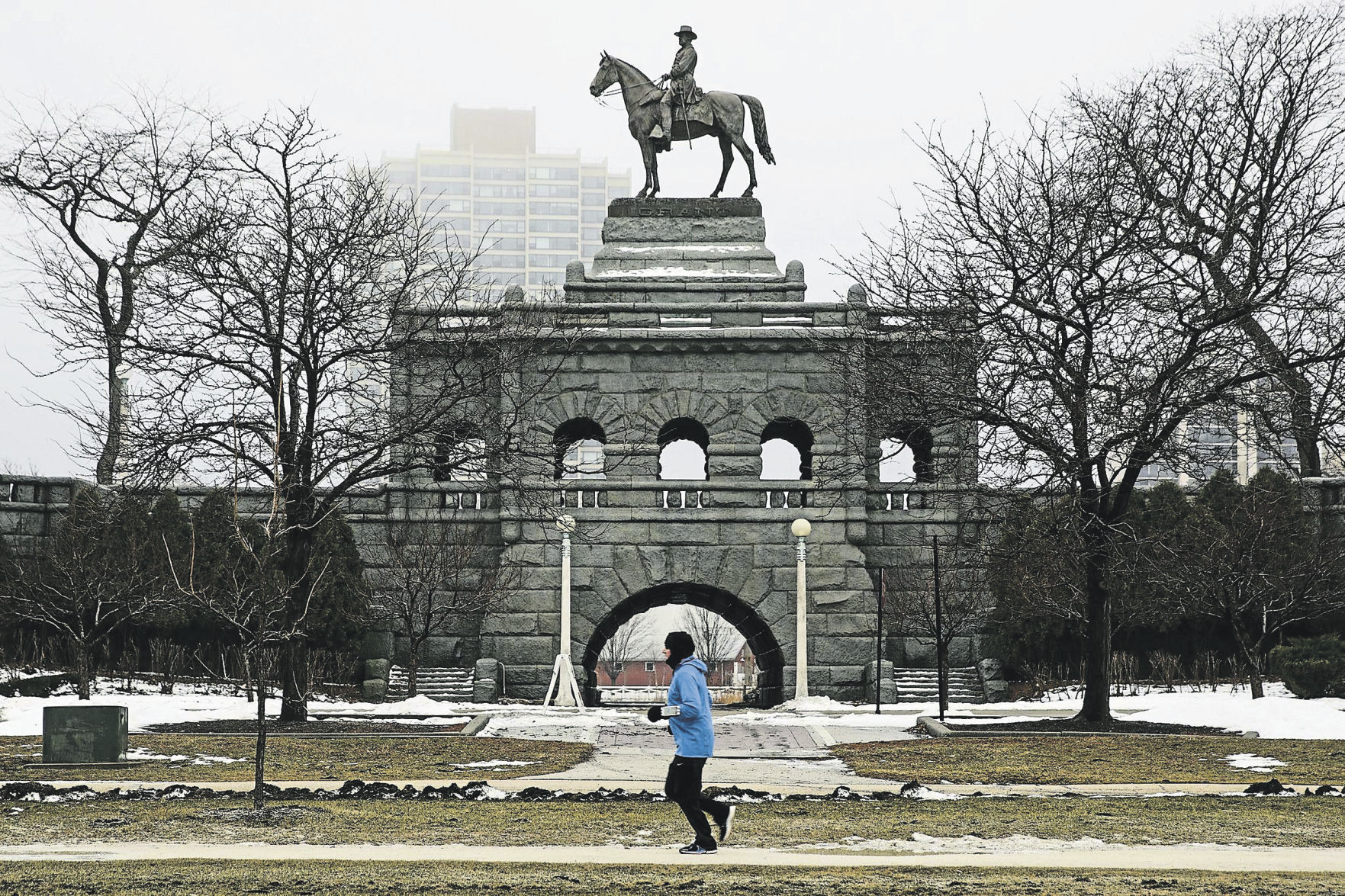 A jogger runs by the Ulysses S. Grant Monument south of Lincoln Park Zoo in Chicago on a cold and foggy morning in 2018.    PHOTO CREDIT: Jose M. Osorio