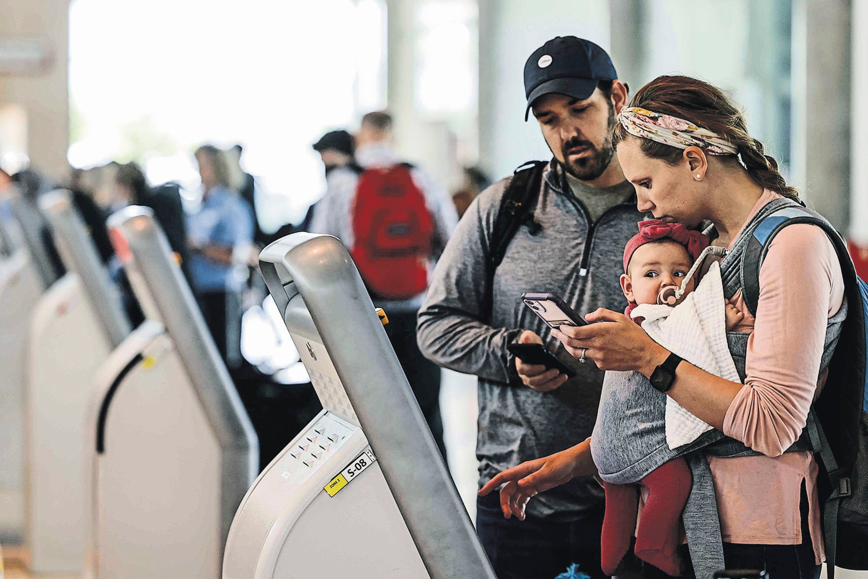 Zach and Cheryl Steifel, of Dallas, with their 4-month-old daughter Emery, check in for their flight to Nashville at Dallas Love Field Airport. Ticket costs are increasing, as more people are flying and carriers face high fuel costs.    PHOTO CREDIT: Tribune News Service