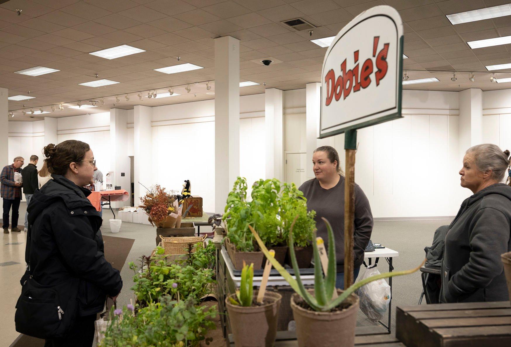 Sheila “Dobie” Merfeld, (right), and her daughter Tracy Merfeld, (center) chat with customer Jennifer Andress during the Dubuque winter farmers market at Kennedy Mall in April.    PHOTO CREDIT: Stephen Gassman