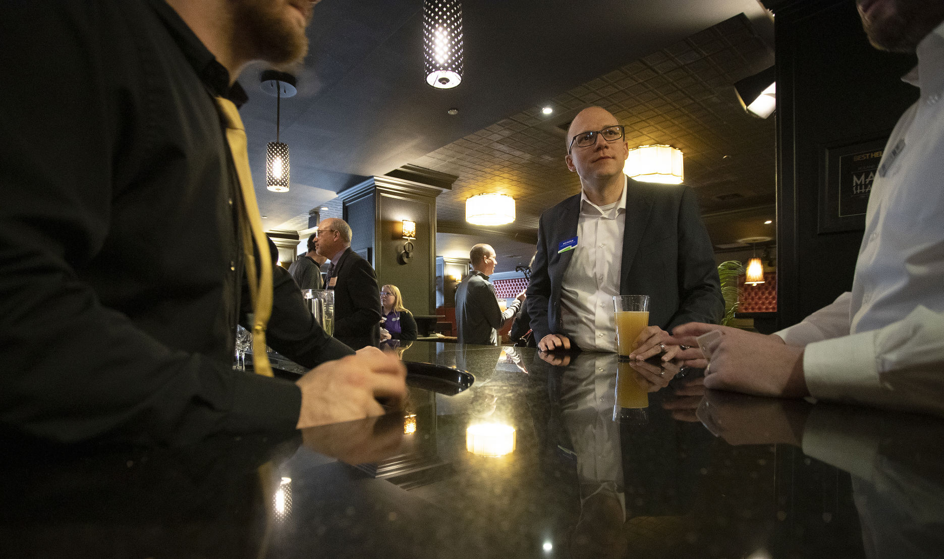 Nick Patrum, vice president, commercial banker team lead for Dubuque Bank & Trust, chats with others at the Executive Meet and Greet in the Riverboat Lounge at Hotel Julien Dubuque on Tuesday, April. 19, 2022.    PHOTO CREDIT: Stephen Gassman