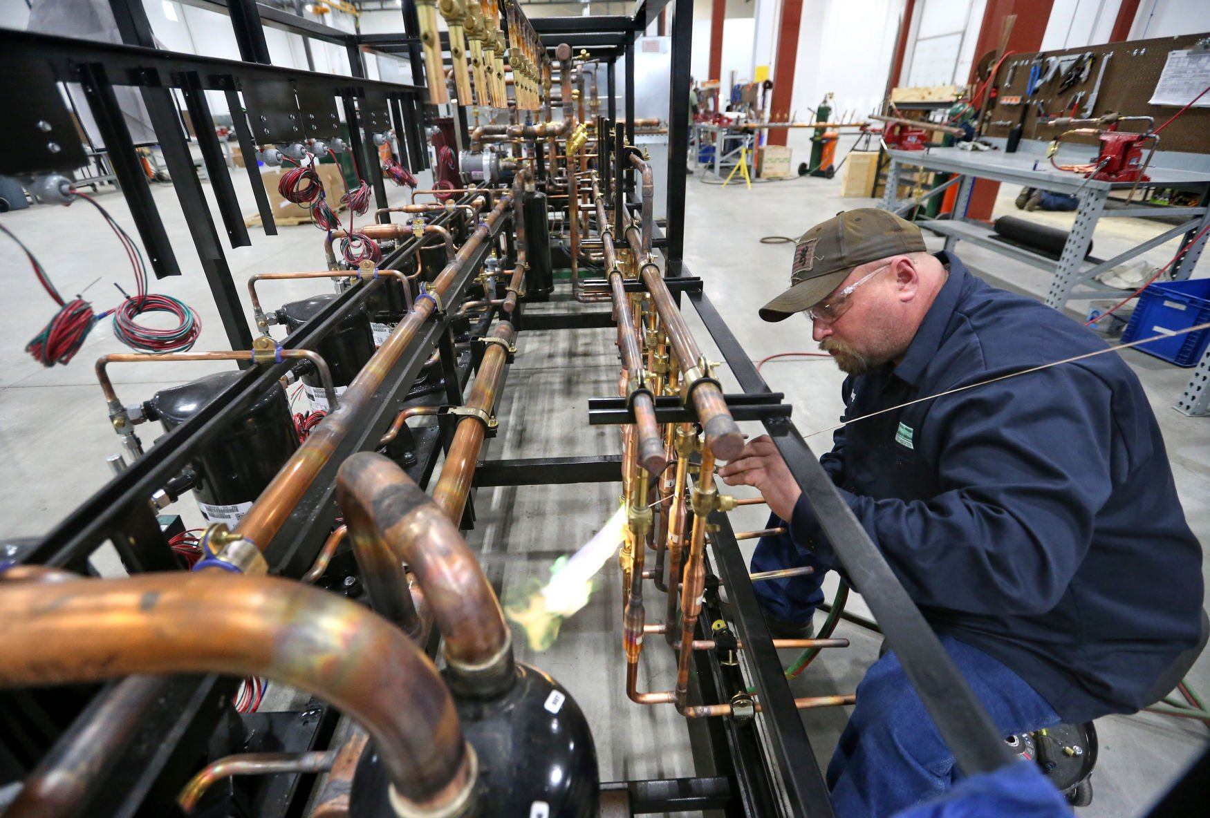 Doug Knight works on brazing a pipe on an industrial refrigeration unit at Zero Zone in Dyersville, Iowa, on Thursday.    PHOTO CREDIT: JESSICA REILLY