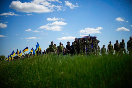 Ukrainian soldiers carry the coffin of Volodymyr Losev, 38, during his funeral in Zorya Truda, Odesa region, Ukraine, Monday, May 16, 2022. Volodymyr Losev, a Ukrainian volunteer soldier, was killed May 7 when the military vehicle he was driving ran over a mine in eastern Ukraine. (AP Photo/Francisco Seco)    PHOTO CREDIT: Francisco Seco