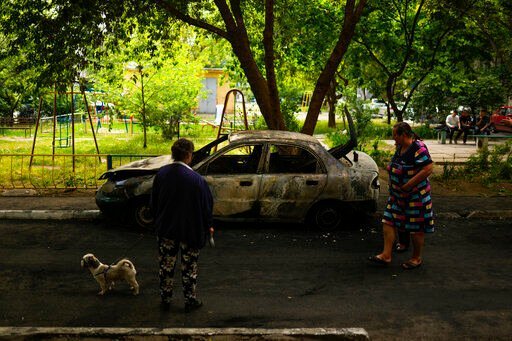 Local residents look at a car burned by a bombing earlier in the day in Mykolaiv, Ukraine, Monday, May 16, 2022. (AP Photo/Francisco Seco)    PHOTO CREDIT: Francisco Seco