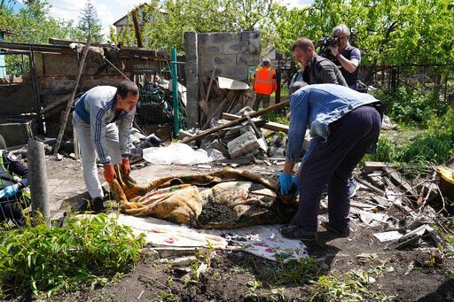 Police and volunteers exhume the body of a civilian killed by Russian shelling in the village of Malaya Rohan, on the outskirts of Kharkiv, Monday, May 16, 2022. (AP Photo/Andrii Marienko)    PHOTO CREDIT: Andrii Marienko
