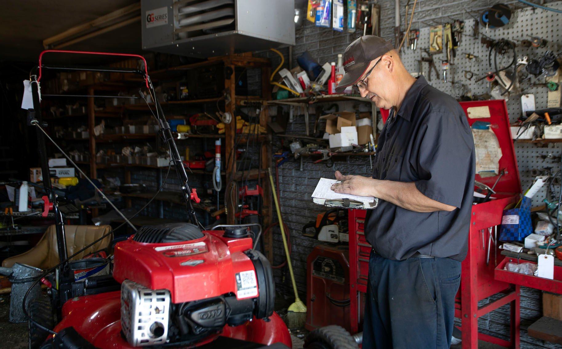 Scott Siefert performs maintenance on a mower in the shop at McGovern Hardware in Dubuque on Thursday, May 12, 2022.    PHOTO CREDIT: Stephen Gassman