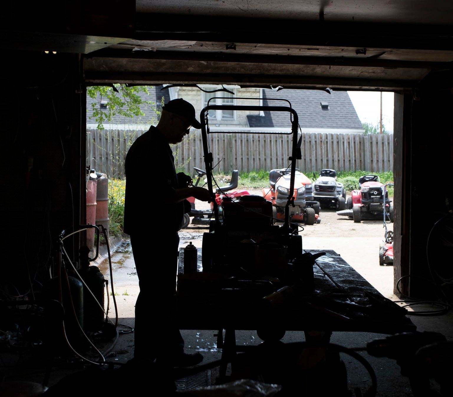 Scott Siefert performs maintenance on a mower in the shop at McGovern Hardware in Dubuque on Thursday.    PHOTO CREDIT: Stephen Gassman