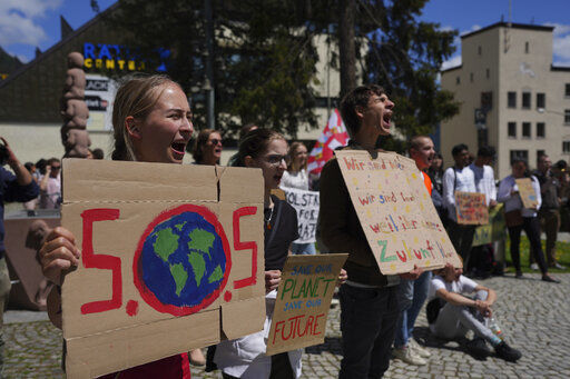 Climate activists perform with posters during a climate protest alongside the World Economic Forum in Davos, Switzerland, Thursday, May 26, 2022. The annual meeting of the World Economic Forum is taking place in Davos from May 22 until May 26, 2022. (AP Photo/Evgeniy Maloletka)    PHOTO CREDIT: Evgeniy Maloletka
