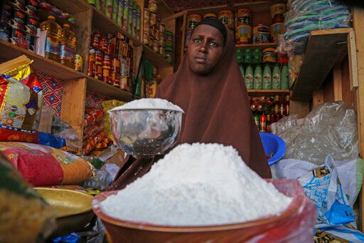 A shopkeeper sells wheat flour in the Hamar-Weyne market in the capital Mogadishu, Somalia Thursday, May 26, 2022. Families across Africa are paying about 45% more for wheat flour as Russia