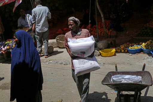 A man carries a sack of wheat flour imported from Turkey in the Hamar-Weyne market in the capital Mogadishu, Somalia Thursday, May 26, 2022. Families across Africa are paying about 45% more for wheat flour as Russia