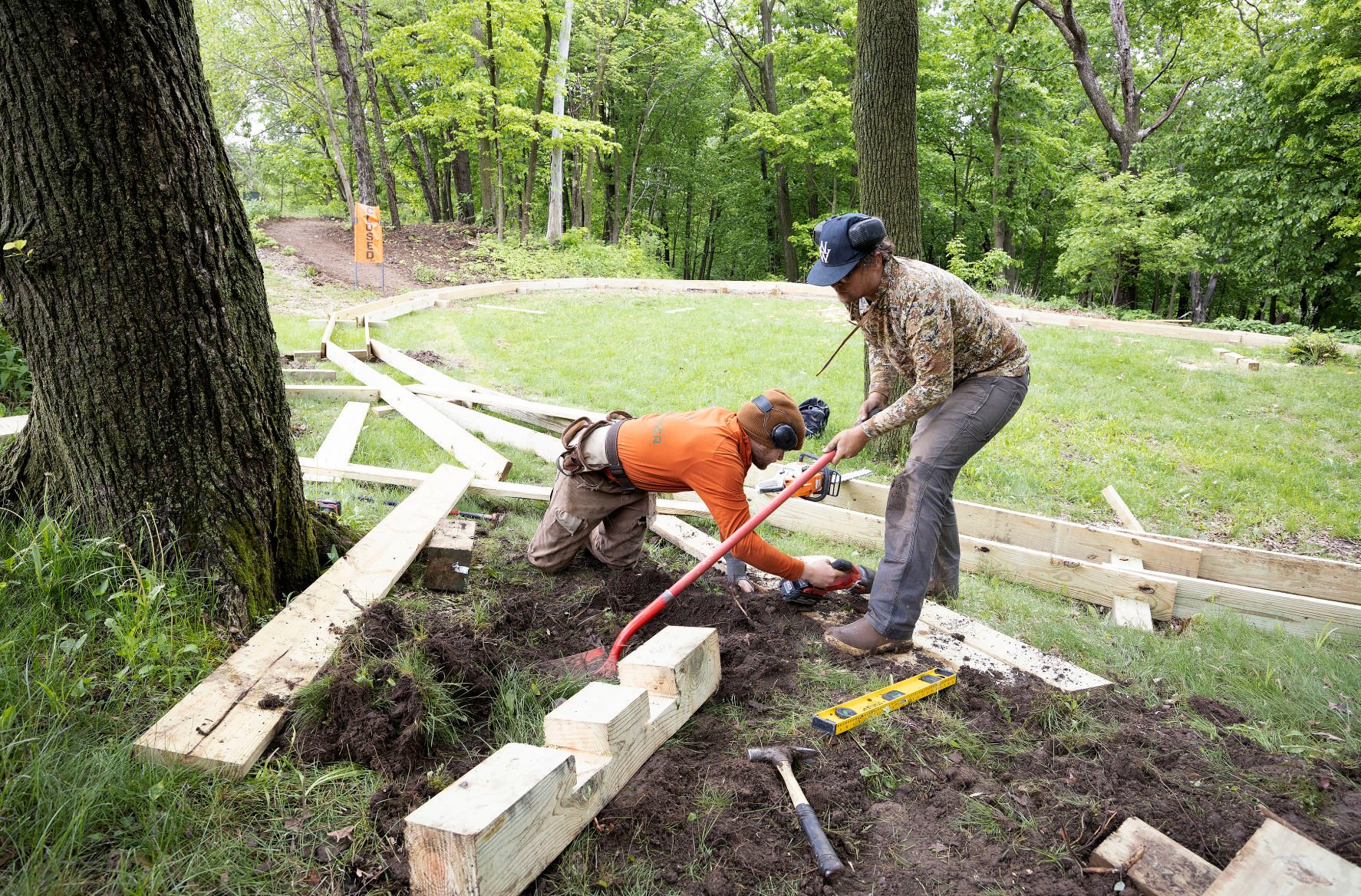 Tanner Williams (left) and Nate Speer, of Pathfinder Trail Building, of Eagan, Minn., work on a new mountain bike trail at Chestnut Mountain Resort in Galena, Ill., on Friday. The bike trails could open in the late summer.    PHOTO CREDIT: Stephen Gassman