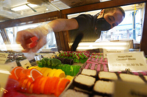 Beth Duckworth fills a display cabinet with sweet treats at The Goldenrod, a popular restaurant and candy shop, Wednesday, June 1, 2022, in York Beach, Maine. The business is looking to hire 30 to 40 more workers in addition to the 70 or so it now employs. (AP Photo/Robert F. Bukaty)    PHOTO CREDIT: Robert F. Bukaty