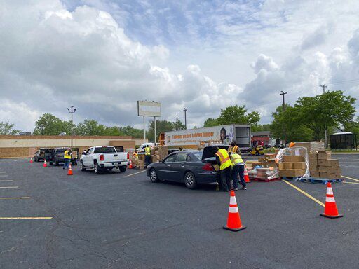 In this image provided by the Northern Illinois Food Bank, volunteers distribute food items from the Northern Illinois Food Bank on May 26, 2022, in Rockford, Ill. Americans at the low end of the income rung are once again struggling to make ends meet. A confluence of factors — the expiration of federal stimulus checks and surging inflation on staples like gas and food — are driving an even bigger wedge between the haves and have-nots. (Northern Illinois Food Bank via AP)    PHOTO CREDIT: HONS