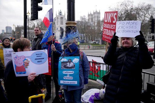 FILE - Anti-Boris Johnson and anti-Brexit protesters hold placards by Parliament Square, in London, Wednesday, Jan. 26, 2022. Britain’s governing Conservatives will hold a no-confidence vote in Prime Minister Boris Johnson on Monday, June 6, 2022 that could oust him as Britain’s leader. Johnson has been struggling to turn a page on months of ethics scandals, most notably over rule-breaking parties in government buildings during COVID-19 lockdowns. (AP Photo/Matt Dunham, File)    PHOTO CREDIT: Matt Dunham