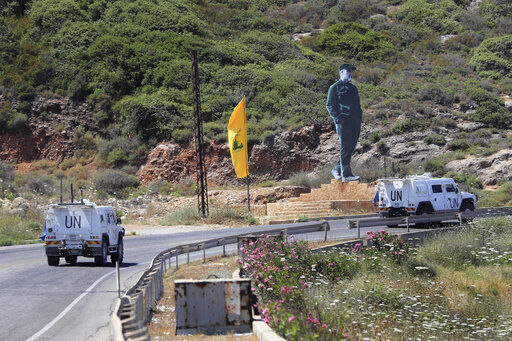 CORRECTS TO SAY CALLED TO RESUME INDIRECT TALKS NOT RESUMED TALKS - U.N. peacekeeping vehicles pass a Hezbollah flag and a statue of the late Iranian General Qassem Soleimani, as they patrol on a road along the Lebanese-Israeli border town of Naqoura, while Lebanon and Israel are being called to resume indirect talks over their disputed maritime border with U.S. mediation, south Lebanon, Monday, June 6, 2022. The Lebanese government invited on Monday a U.S. envoy mediating between Lebanon and Israel over their disputed maritime border to return to Beirut as soon as possible to work out an agreement amid rising tensions along the border. (AP Photo/Mohammed Zaatari)    PHOTO CREDIT: Mohammad Zaatari