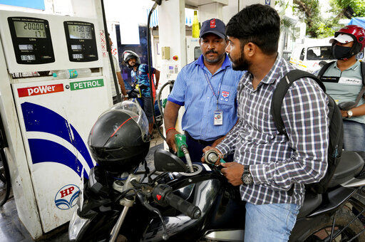 A motorcyclists watches as an employee of a fuel stationin fills petrol, in Mumbai, India, Saturday, June 11, 2022. India and other Asian nations are becoming an increasingly vital source of oil revenues for Moscow as the U.S. and other Western countries cut their energy imports from Russia in line with sanctions over its war on Ukraine. (AP Photo/Rajanish kakade)    PHOTO CREDIT: Rajanish Kakade