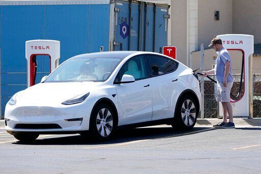 FILE - A Tesla owner charges his vehicle at a charging station in Topeka, Kan., Monday, April 5, 2021. Tesla reported 273 crashes involving partially automated driving systems, according to statistics released by U.S. safety regulators on Wednesday, June 15, 2022. But the National Highway Traffic Safety Administration cautioned against using the numbers to compare automakers, saying it didn’t weigh them by the number of vehicles from each manufacturer that use the systems, or how many miles those vehicles traveled. (AP Photo/Orlin Wagner, File)    PHOTO CREDIT: Orlin Wagner