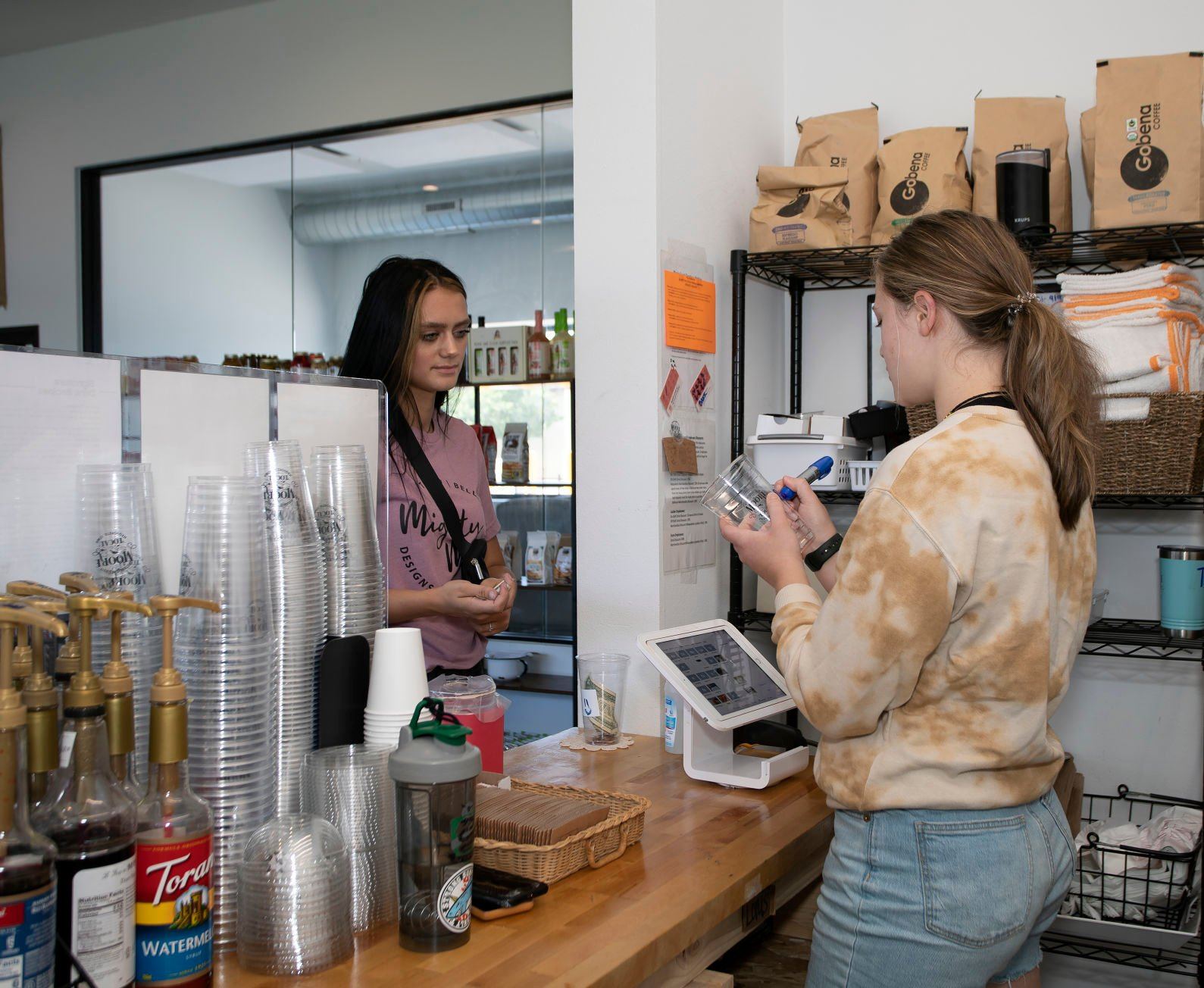 Employee Ella Tracy takes a coffee order from Terrin Beck at Moore Local, 305 S. Riverview St., in Bellevue, Iowa on Thursday.    PHOTO CREDIT: Stephen Gassman