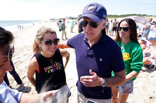 President Joe Biden talks to the media after walking on the beach with his granddaughter Natalie Biden (left) and his daughter Ashley Biden (right). Biden says he’s considering a federal holiday on the gasoline tax. That could possibly save Americans as much as 18.4 cents a gallon.    PHOTO CREDIT: Manuel Balce Ceneta