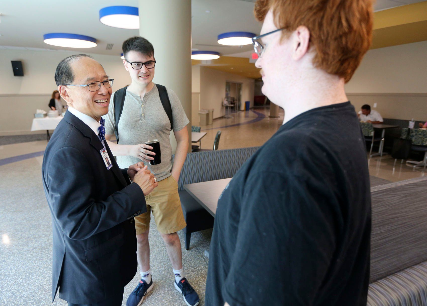 Students Tim Johnson (center) and Robert Craker (right) chat with departing Northeast Iowa Community College President Liang Chee Wee during his goodbye ceremony held at the Peosta campus Wednesday.    PHOTO CREDIT: Dave Kettering