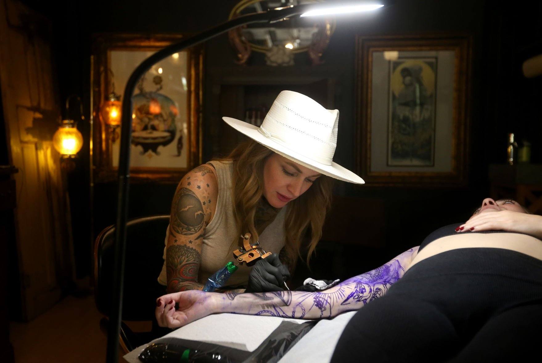 Owner Sarah Anderson tattoos Chelsey Shone, of Fayetteville, Ark., at Goldies in Dubuque on Friday, June 24, 2022. Anderson recently opened the tattoo studio at 251 W. Eighth St.    PHOTO CREDIT: JESSICA REILLY