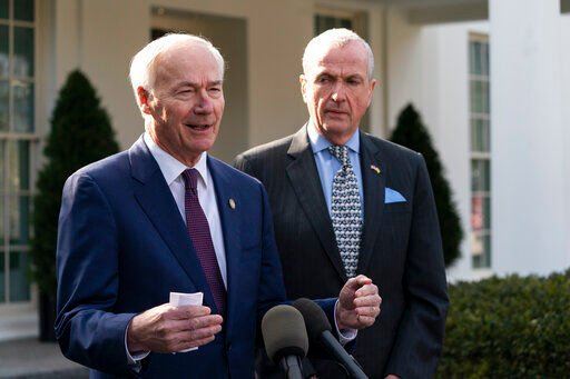 Arkansas Gov. Asa Hutchinson, R-Ark., (left) and New Jersey Gov. Phil Murphy, D-N.J., speak with reporters outside during a meeting with the National Governors Association. Stark political divides are overshadowing a meeting this week of the nation