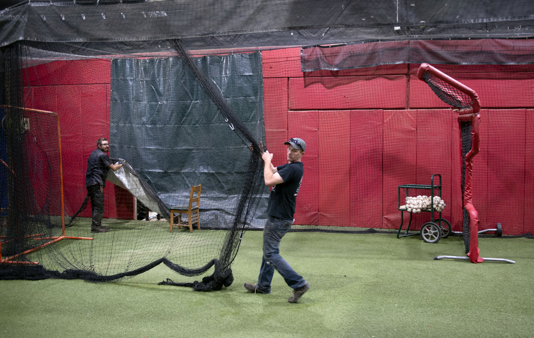 Matt Delaney pulls netting across the hitting area at Between the Laces batting cages facility in Farley.    PHOTO CREDIT: Dave LaBelle