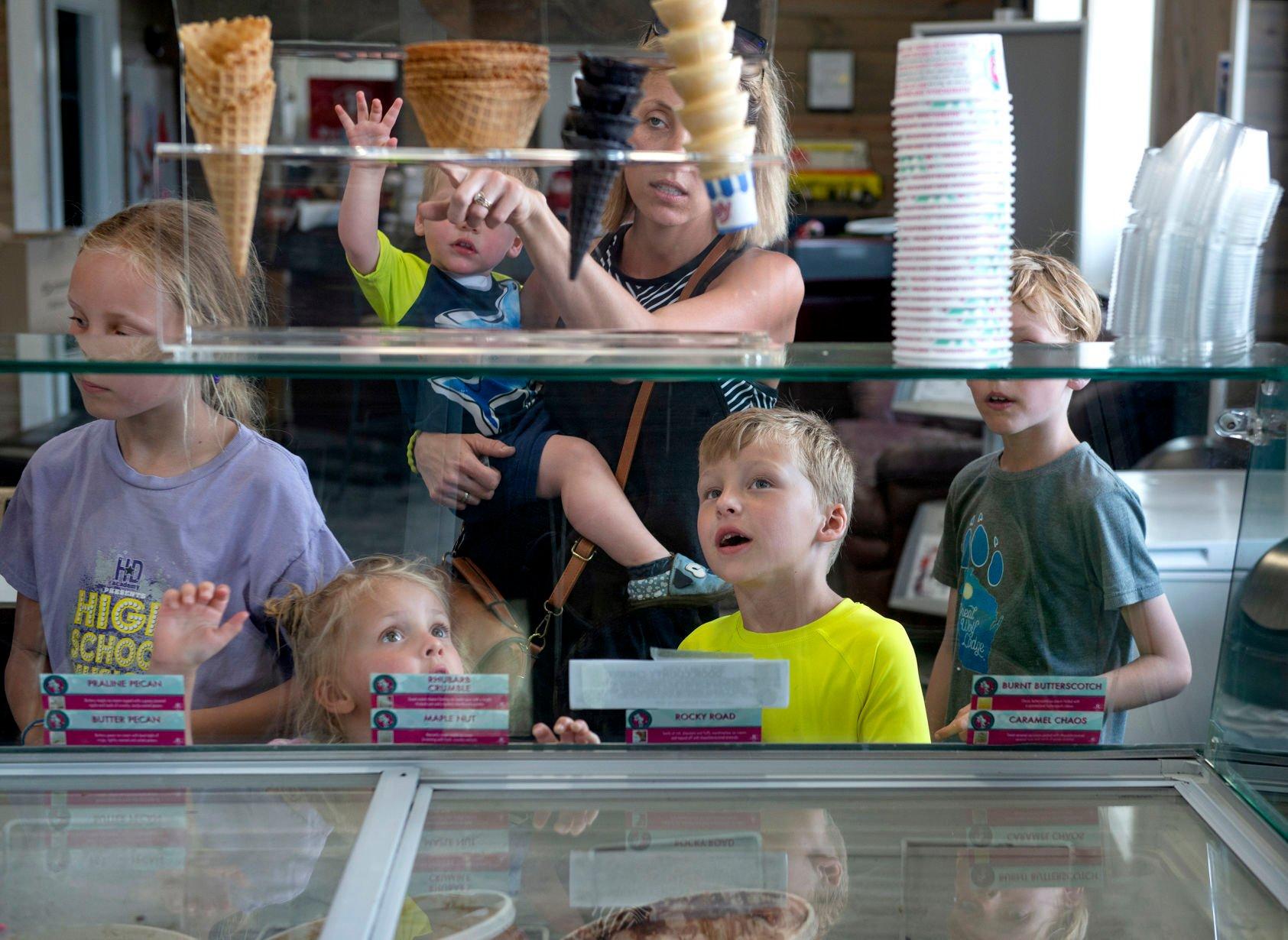 Members of the Rupp family (from left, Lily, Gracelyn, Oliver, Emmalee, Miles and Sawyer) look over the choices of ice cream and cones at Delaney’s Ice Cream Shoppe in Farley, Iowa.    PHOTO CREDIT: Dave LaBelle