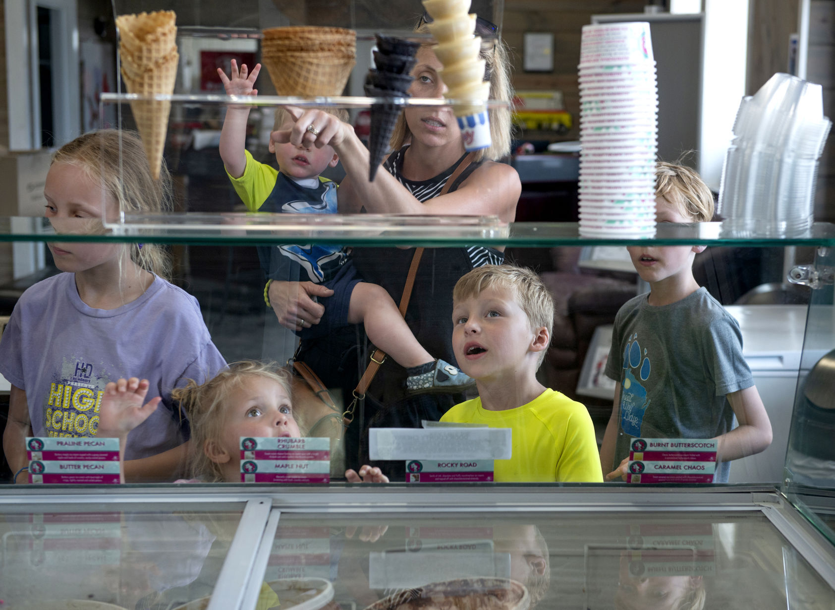 Members of the Rupp family (from left, Lily, Gracelyn, Oliver, Emmalee, Miles and Sawyer) look over the choices of ice cream and cones at Delaney’s Ice Cream Shoppe in Farley, Iowa.    PHOTO CREDIT: Dave LaBelle