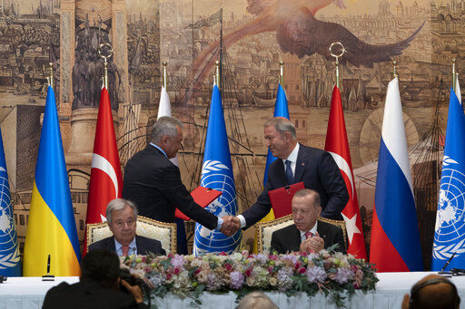 IDENTIFIES TWO PEOPLE SHAKING HANDS - Turkish President Recep Tayyip Erdogan, right, and U.N. Secretary General, Antonio Guterres, sit as Sergei Shoigu, Russia