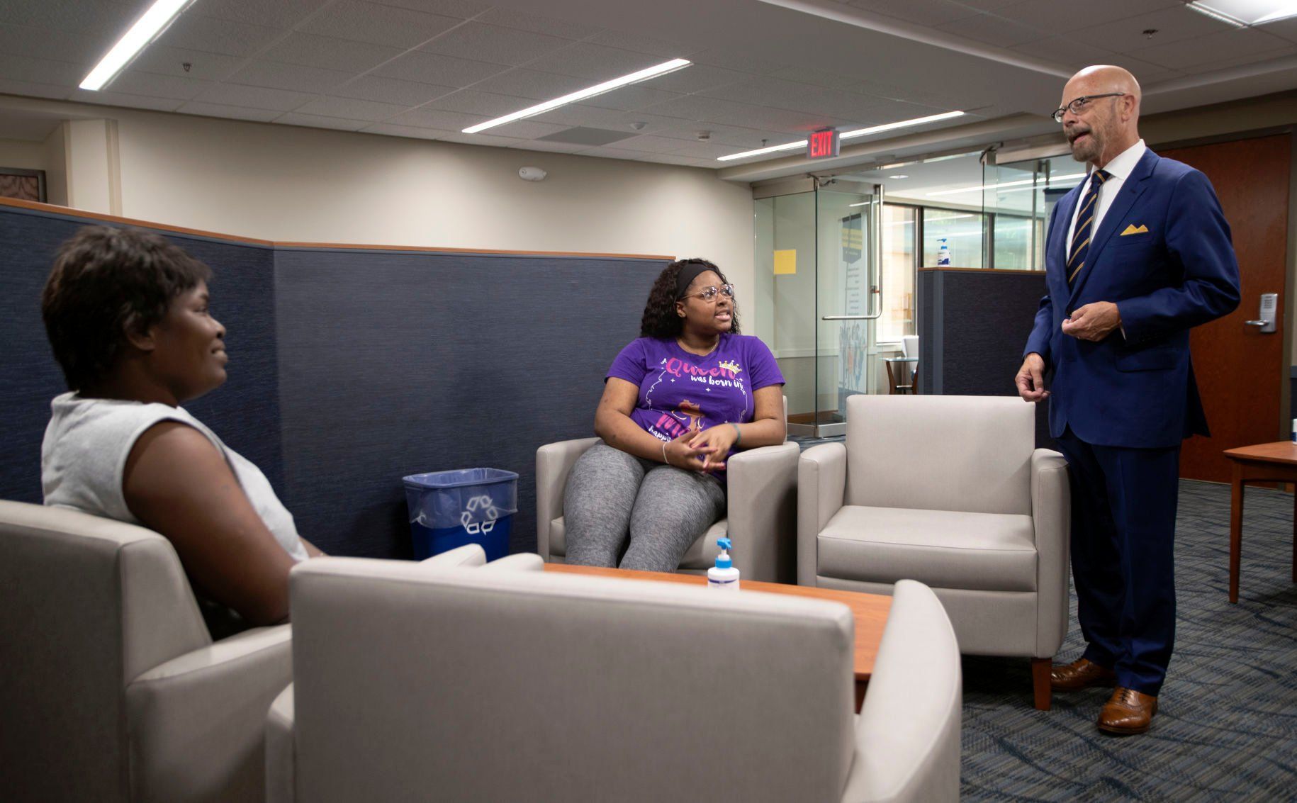 Herbert Riedel speaks with students Yolanda McDougal (left) and Breonna Doss at the Dubuque campus.    PHOTO CREDIT: Stephen Gassman