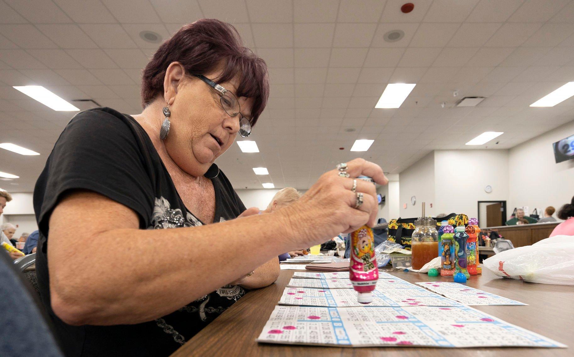 Karen Case marks her cards during bingo night at the Tri-State Independent Blind Society in Dubuque on Wednesday, July 3, 2022.    PHOTO CREDIT: Stephen Gassman