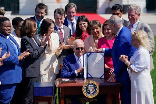 President Joe Biden holds the "CHIPS and Science Act of 2022" after signing it during a ceremony on the South Lawn of the White House, Tuesday, Aug. 9, 2022, in Washington. (AP Photo/Evan Vucci)    PHOTO CREDIT: Evan Vucci