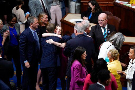 Members of the House of Representatives gather in the chamber to celebrate after the vote to approve the Inflation Reduction Act at the Capitol in Washington, Friday, Aug. 12, 2022. A divided Congress gave final approval Friday to Democrats
