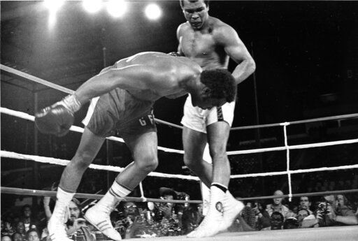 FILE - Challenger Muhammad Ali, right, watches as defending world champion George Foreman goes down to the canvas in the eighth round of their WBA/WBC championship match, on Oct. 30, 1974, in Kinshasa, Zaire. A mint condition Mickey Mantle baseball card has sold for $12.6 million, blasting into the record books Sunday Aug. 28, 2022 as the most expensive ever paid for a piece of sports memorabilia. It easily surpassed the $6.2 million for the heavyweight boxing belt reclaimed by Muhammad Ali during 1974