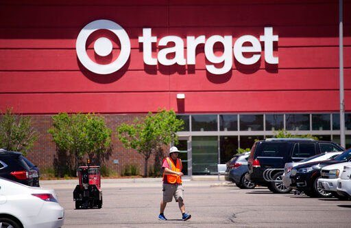 FILE - A worker collects shopping carts in the parking lot of a Target store on Wednesday, June 9, 2021, in Highlands Ranch, Colo. Target reported solid sales for the fiscal second quarter of 2022, but its profits plunged nearly 90% because it slashed prices to clear inventories of clothing, home goods and other discretionary items. (AP Photo/David Zalubowski, File)    PHOTO CREDIT: David Zalubowski