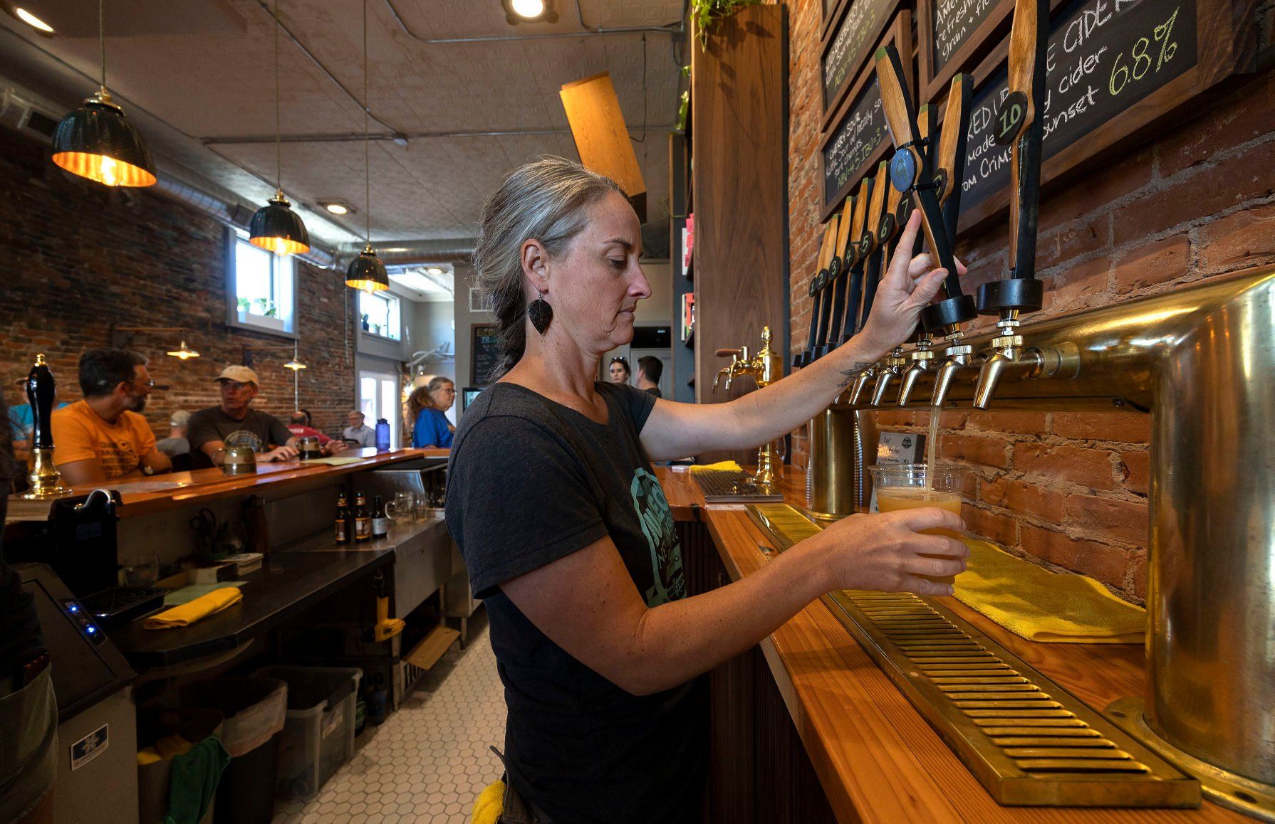 Tap room manager Mary Kay McDermott pours a beer at the newly expanded Jubeck New World Brewing in Dubuque on Wednesday, Aug. 31, 2022.    PHOTO CREDIT: Stephen Gassman