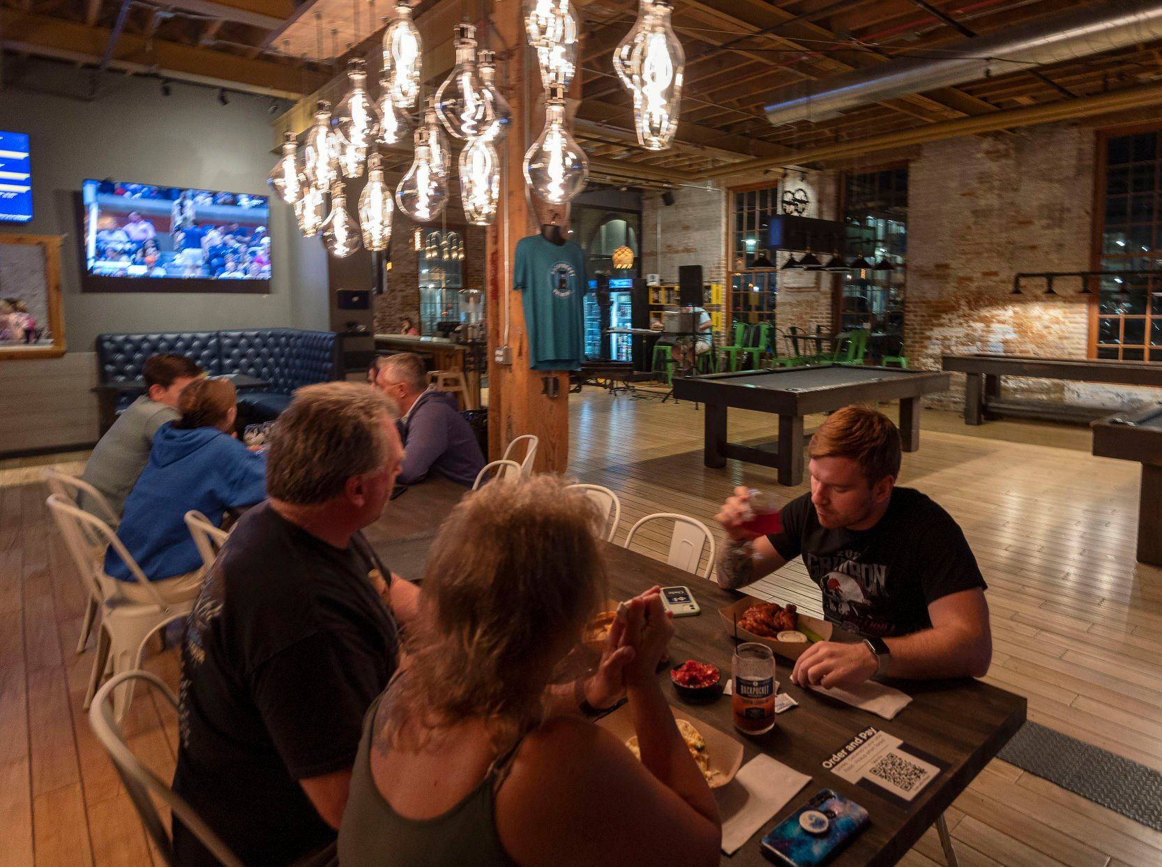 Teams play trivia at Backpocket Taproom in Dubuque. The events draw in people on weekday evenings, which normally aren’t busy. It boosts sales and many customers return each week for the contests.    PHOTO CREDIT: Stephen Gassman