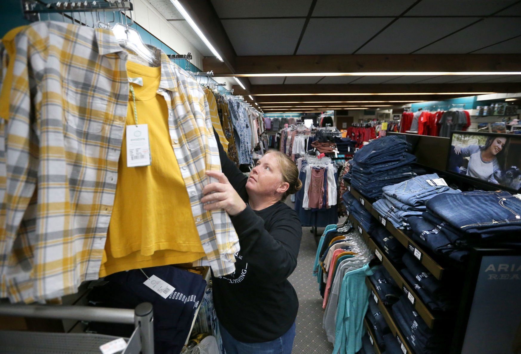 Tammy Beesecker arranges clothing.    PHOTO CREDIT: JESSICA REILLY