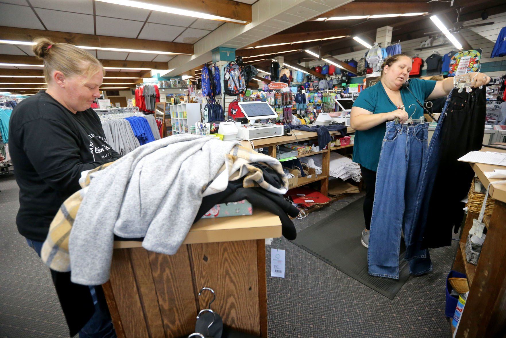 Beesecker (left) sorts clothes while Stepfanie Mossner talks to a customer on the phone. The Lancaster business started in 1928.    PHOTO CREDIT: JESSICA REILLY