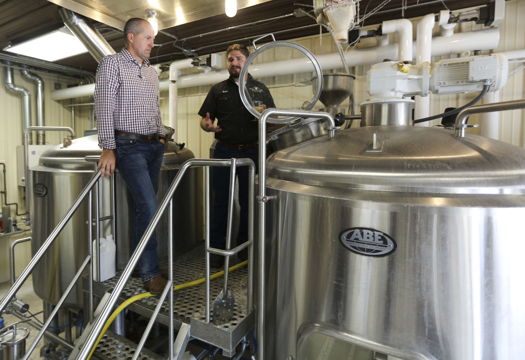 Iowa Secretary of Agriculture Mike Naig (left) listens to Franklin Street Brewing Company brew master, Matt Knutson, explain the brewing process during a tour of the facility located in Manchester, Iowa, on Thursday, Sept. 15, 2022.    PHOTO CREDIT: Dave Kettering