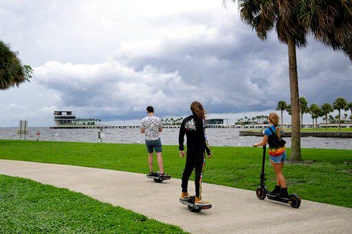 People ride along the bayfront as an outer band of Hurricane Ian approaches and kicks up the surf at Vinoy Park, Tuesday, Sept. 27, 2022, in St. Petersburg, Fla. (AP Photo/Phelan M. Ebenhack)    PHOTO CREDIT: Phelan M. Ebenhack