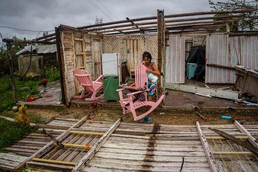 Maria Llonch retrieves her belongings from her home damaged by Hurricane Ian in Pinar del Rio, Cuba, Tuesday.    PHOTO CREDIT: Ramon Espinosa, The Associated Press
