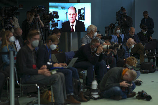 German Chancellor Olaf Scholz displayed on a screen during a news conference about the German energy supply with Economy and Climate Minister Robert Habeck and Finance Minister Christian Lindner at the chancellery in Berlin, Germany, Thursday, Sept. 29, 2022. Scholz appears via videolink as he is in quarantine for coronavirus. (AP Photo/Markus Schreiber)    PHOTO CREDIT: Markus Schreiber