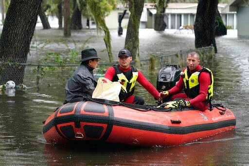 Residents in an Orlando, Fla., neighborhood are rescued due to floodwaters from Hurricane Ian, Thursday, Sept. 29, 2022. (AP Photo/John Raoux)    PHOTO CREDIT: John Raoux