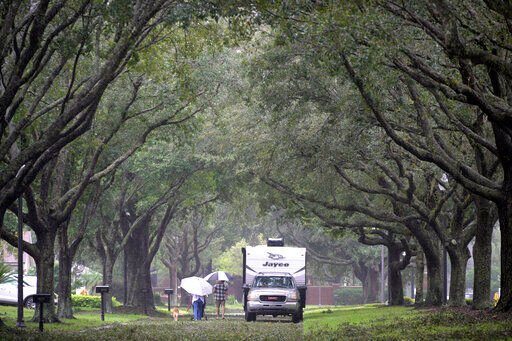 Residents walk through a neighborhood with fallen branches and leaves in the aftermath of Hurricane Ian, Thursday, Sept. 29, 2022, in Orlando, Fla. (AP Photo/Phelan M. Ebenhack)    PHOTO CREDIT: Phelan M. Ebenhack